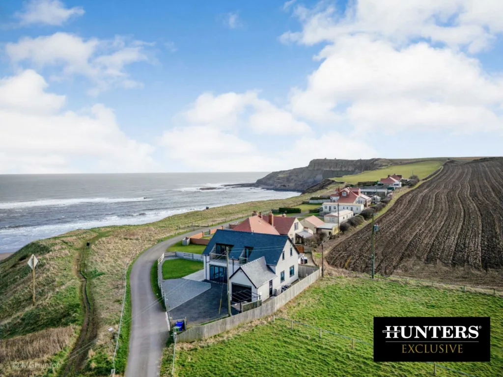 Castle Sunset on the Beach from the air: the house on the clifftop above Cayton Bay, with the beach and headland beyond